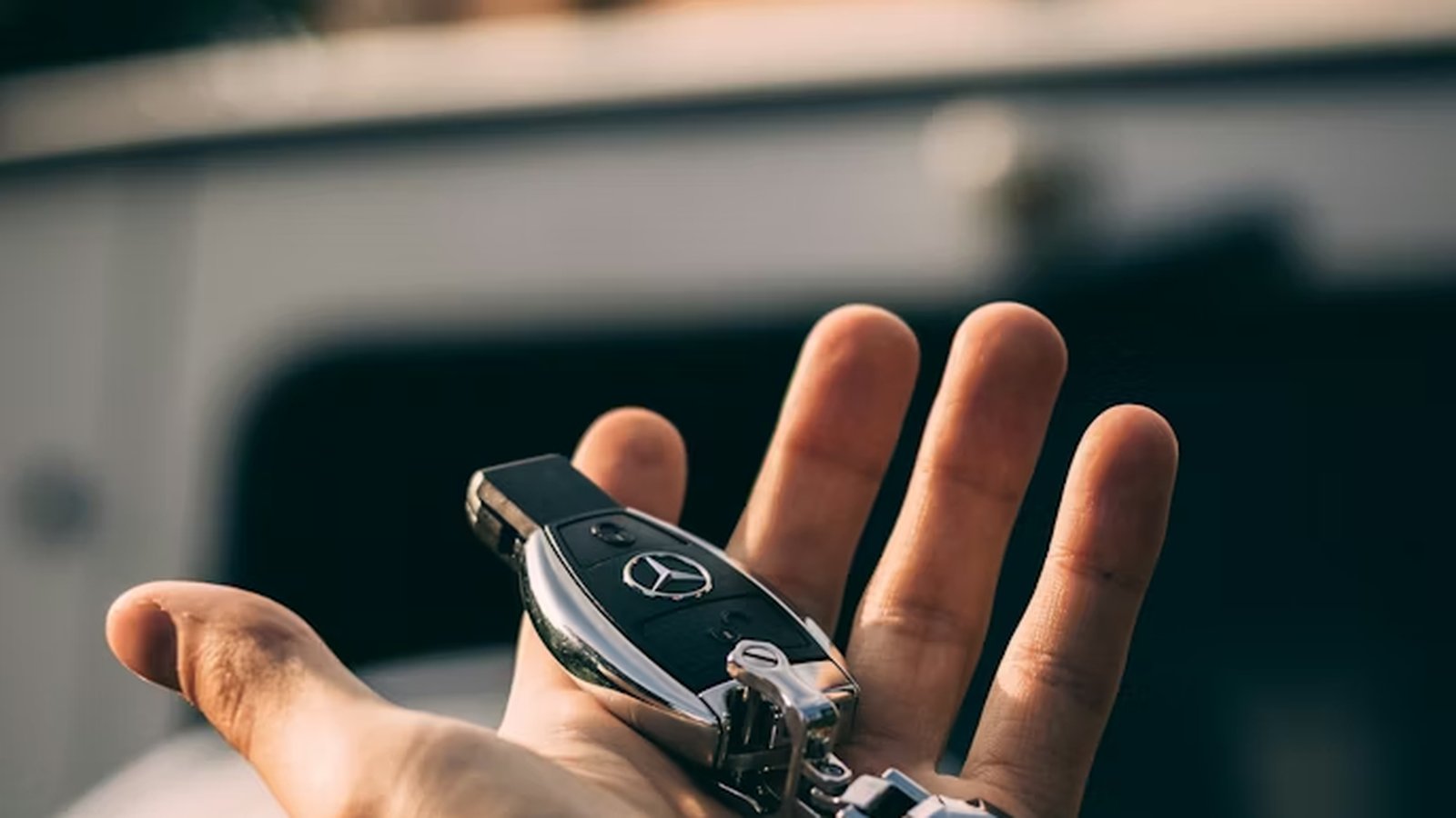 Hand met Mercedes-Benz autosleutel bij sleuteloverdracht